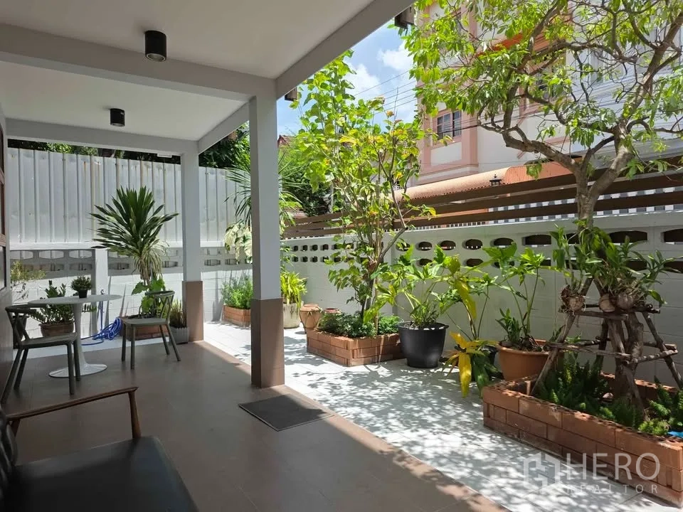 独立式住宅 出租在Khlong Toei, Bangkok - 有顶露台，休闲桌椅与多盆绿植的小庭院。