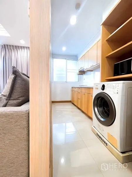 Condominium for rent - View from the living area into the bright kitchen with washing machine and storage.