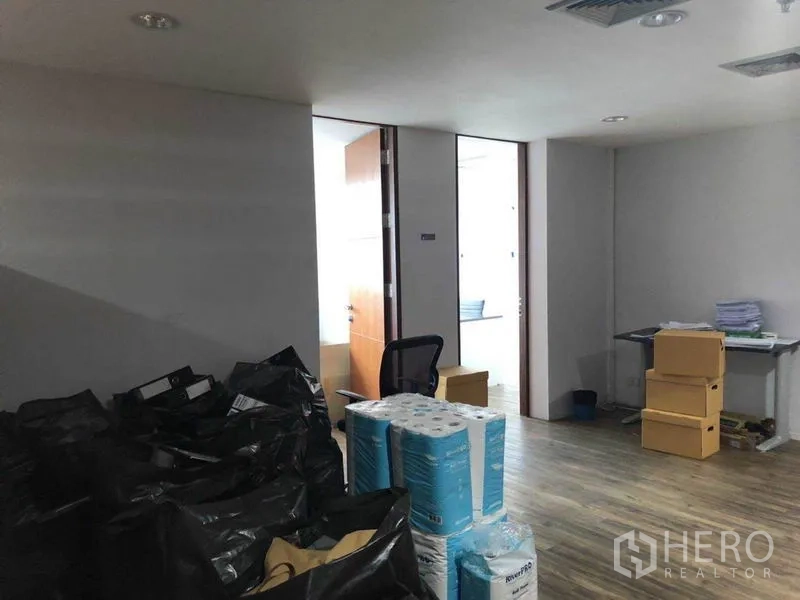 Office Space for sale in Watthana, Bangkok - Back office storage area with supplies and open doorways.