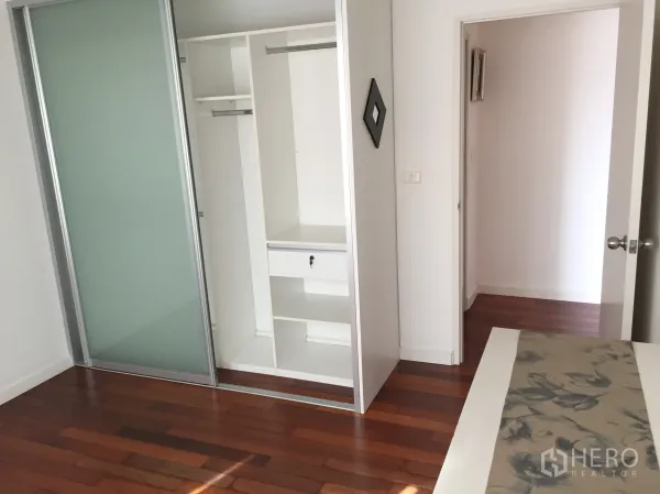 公寓 出租在Watthana, Bangkok - 曼谷瓦他那区公寓卧室，带推拉式衣柜与木地板。