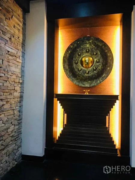 Townhouse for rent in Yan Nawa, Bangkok - Illuminated alcove showcasing a large decorative gong on a stepped pedestal.