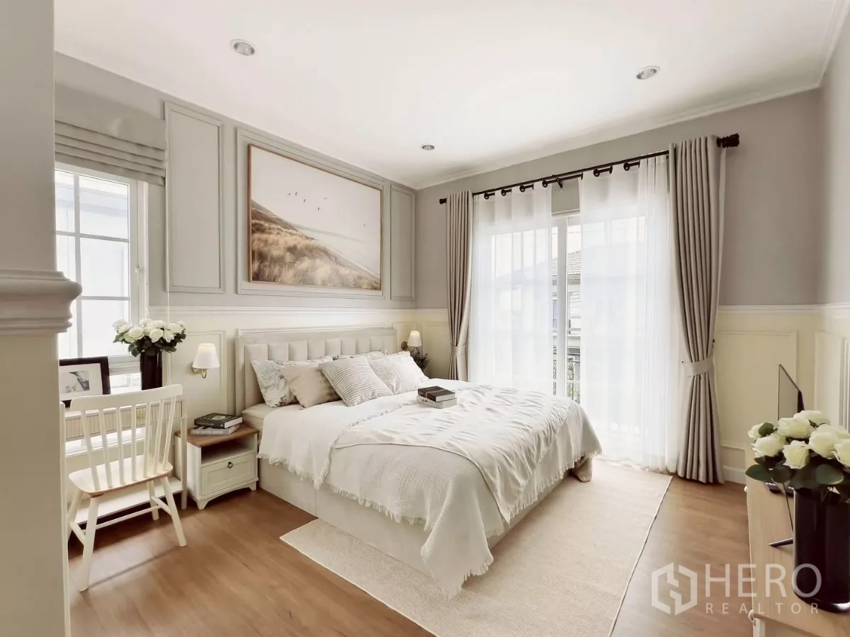 Detached House for rent in Khlong Luang, Pathum Thani - Master bedroom with king bed, desk and large windows with curtains