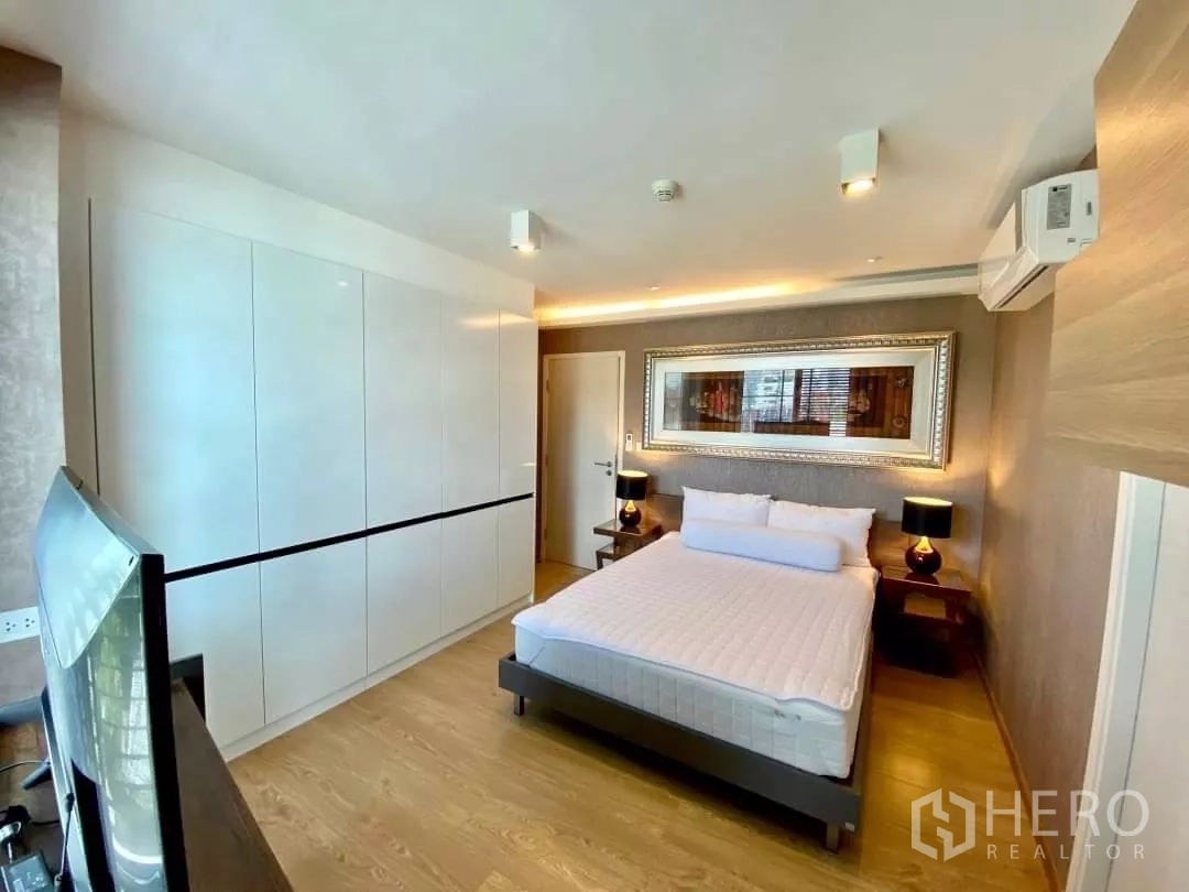 公寓 出租在Watthana, Bangkok - 主卧配内置衣柜、双人床、暖色灯光与空调