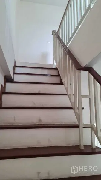 Townhouse for  in Lam Luk Ka, Pathum Thani - Wide interior staircase with wooden treads and white balustrade.