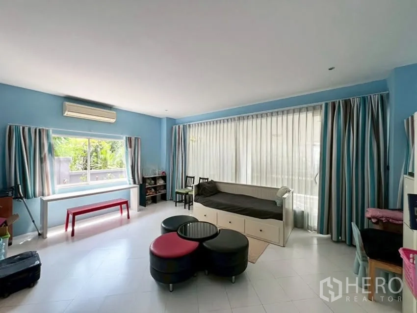 Detached House for rent in Phra Khanong, Bangkok - Multipurpose family room with large windows, daybed, and sheer curtains.