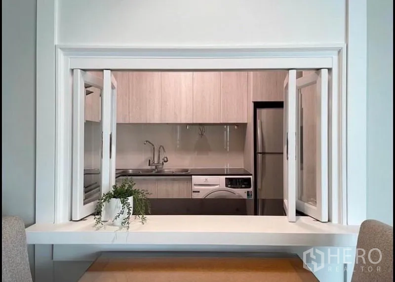 Condominium for rent in Sathon, Bangkok - Pass-through window from kitchen to dining area, showing sink and washer.