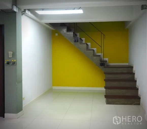 Home Office for rent in Lat Phrao, Bangkok - Internal staircase with a yellow feature wall leading to the upper level.