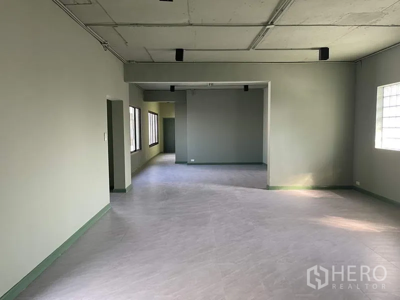 Home Office for rent in Phaya Thai, Bangkok - Open-plan office floor with gray tiles, exposed ceiling tracks and side windows.