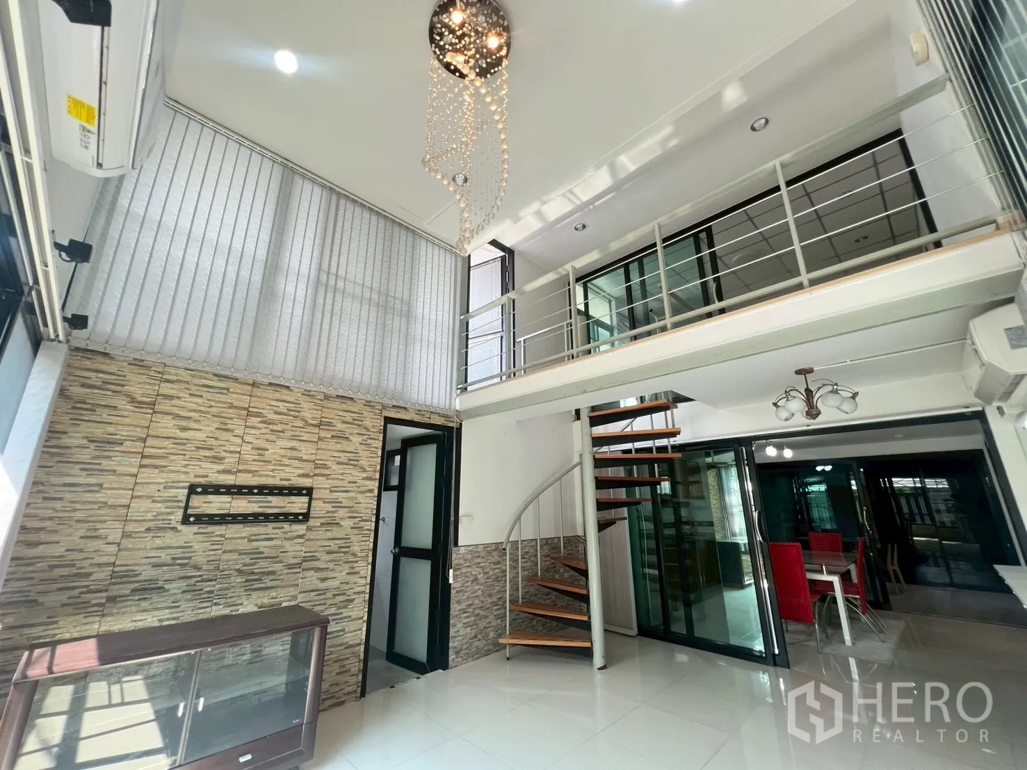 Detached House for rent or sale in Wang Thonglang, Bangkok - Open‑plan living space with spiral staircase leading to mezzanine level.