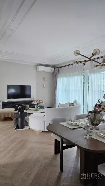 Detached House for rent in Bang Phli, Samut Prakan - Bright open-plan living and dining room with large windows and TV wall.