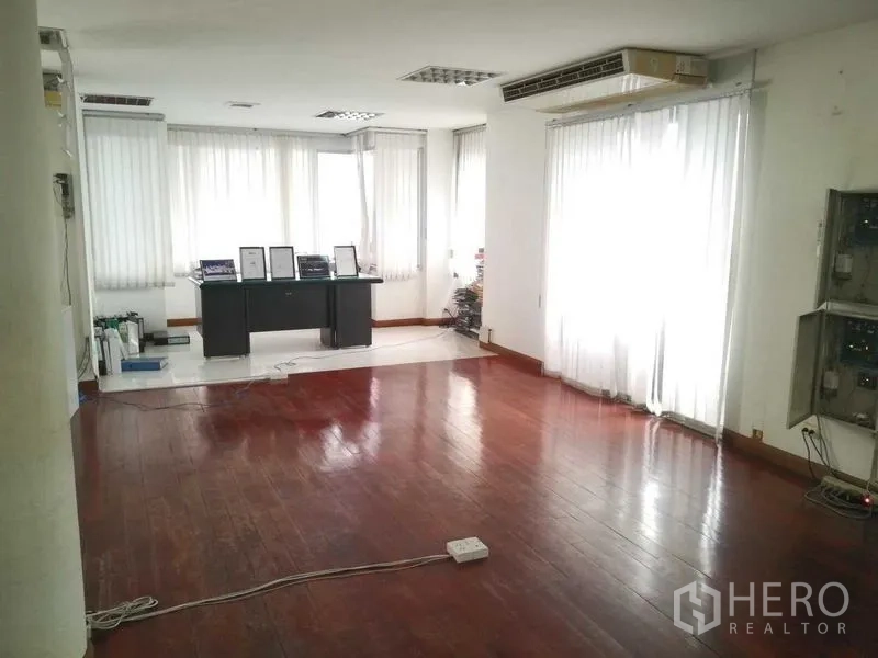 带办公室的家 出租在Saphan Sung, Bangkok - 采光充足的角落办公区，大窗与纱帘、木地板。