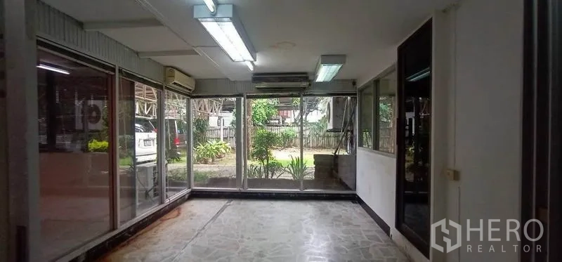 Home Office for rent in Watthana, Bangkok - Glass‑walled room facing the garden, ideal for showroom or reception
