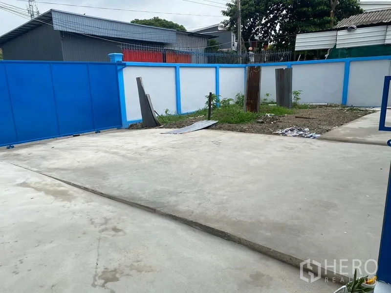 货栈 出租在Bueng Kum, Bangkok - 仓库前封闭式混凝土院子与围墙，适合停车与装卸。