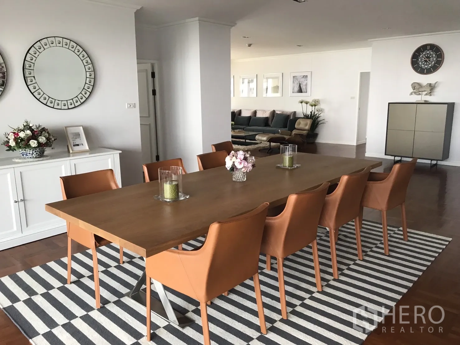Condominium for rent in Bangkok - Wide view of the dining area with tan leather chairs and sideboard, linked to the living room.