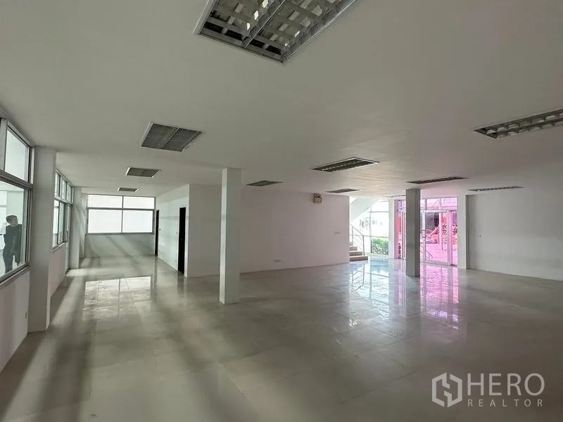 Warehouse for rent in Mueang Samut Prakan, Samut Prakan - Bright office area with fluorescent lighting, glass partitions and wide circulation space.