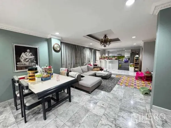 独立式住宅 出租在Suan Luang, Bangkok - 开放式客餐厅，地面为大理石，转角沙发、吊灯与现代中岛厨房。