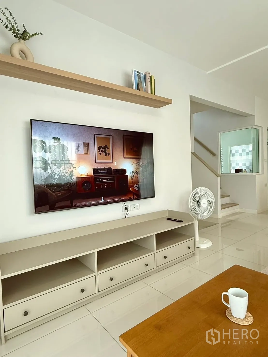 Detached House for rent in Bang Phli, Samut Prakan - Close-up of living room media wall with mounted TV, low console, and shelf decor.