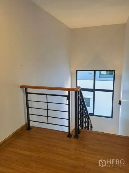 Detached House for rent in Bang Phli, Samut Prakan - Staircase with metal handrail and a large window brightening the landing.