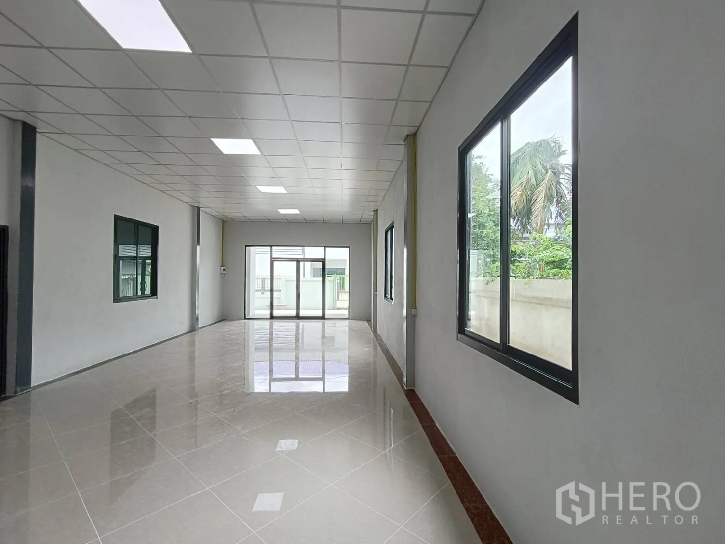 工厂 出租在Lam Luk Ka, Pathum Thani - 长廊式办公室，落地窗与前部玻璃入口，面向院子。