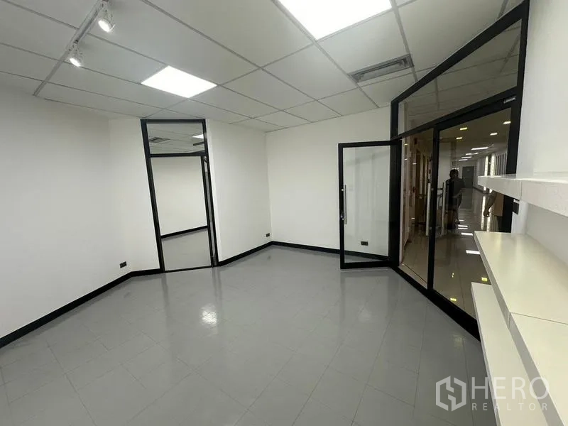 Office Space for rent - Entry area with glass doors and shelving leading to the corridor.