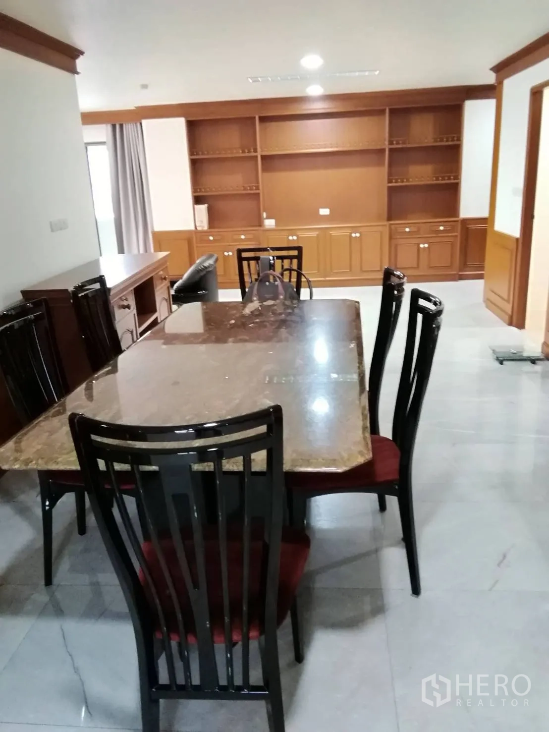 公寓 出租或出售在Watthana, Bangkok - 餐区配大理石餐桌、高靠背椅与墙面置物架。
