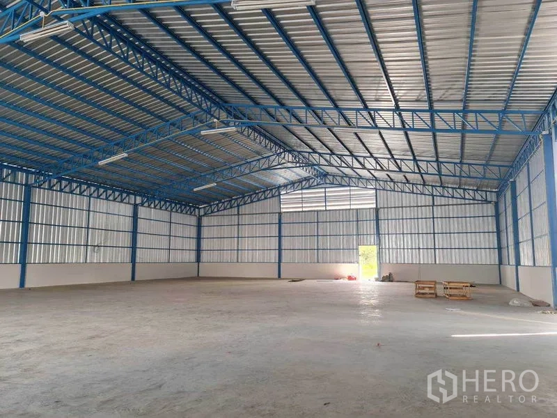 货栈 出租在Nong Chok, Bangkok - 500㎡仓库内部，大跨无柱空间，蓝色钢梁与混凝土地面。