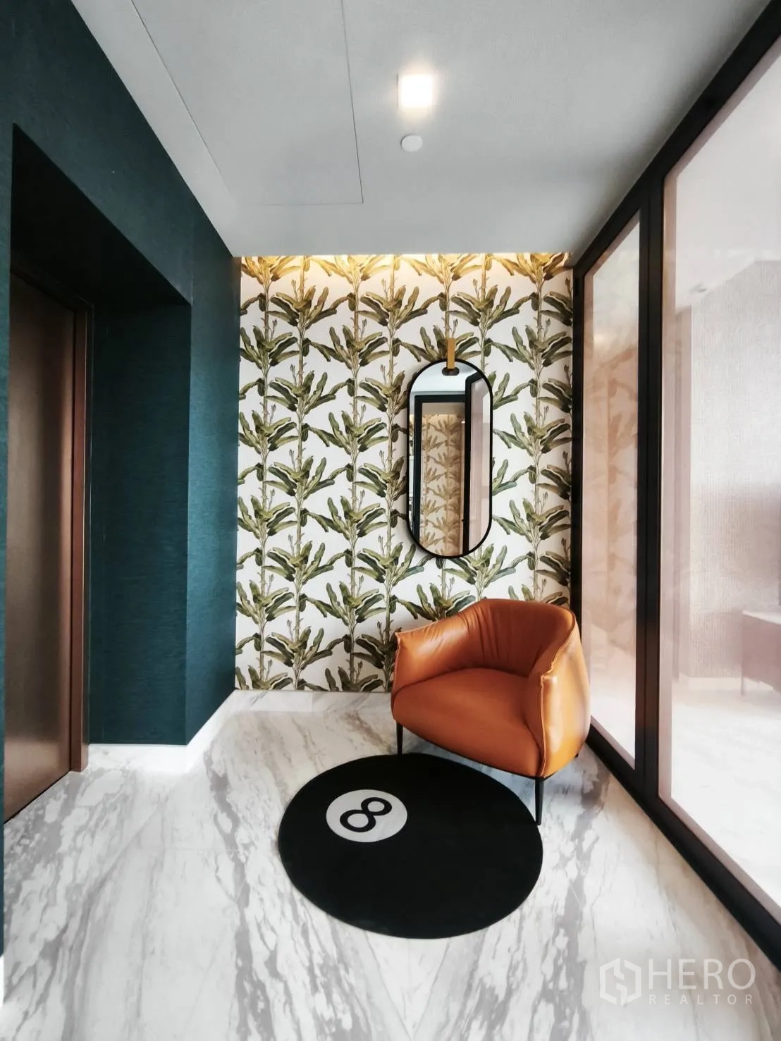 คอนโด for rent in Watthana, Bangkok - โถงทางเข้าตกแต่งลายใบไม้ กระจกเงา และเก้าอี้สีส้ม