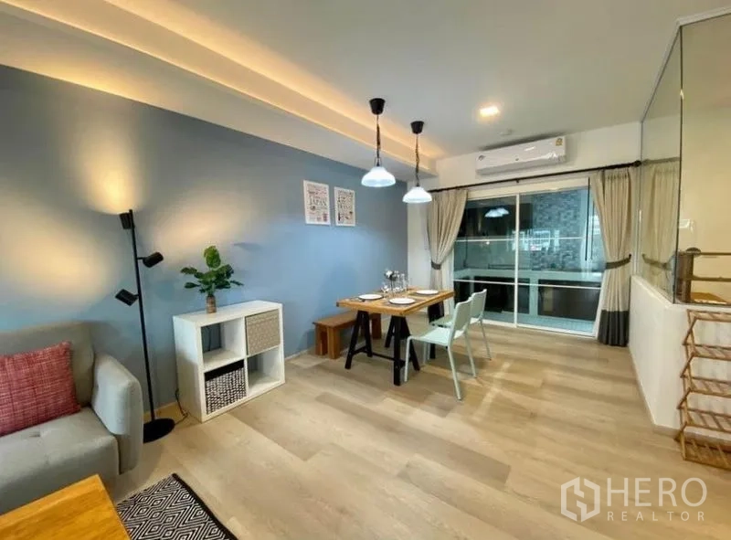 ทาวน์เฮาส์ ให้เช่าในBang Phli, Samut Prakan - โถงนั่งเล่นเชื่อมรับประทานอาหาร ผนังเน้นสีฟ้า แอร์ และประตูกระจกบานเลื่อน