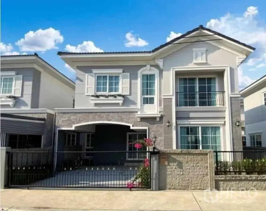 Detached House for sale in Bang Khen, Bangkok - Front facade of a two-storey detached house with covered carport, sliding gate and small garden in Bang Khen.