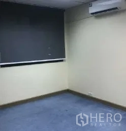 Office Space for rent in Bang Rak, Bangkok - Office corner with blue carpet, wall-mounted air conditioner and blackout window.