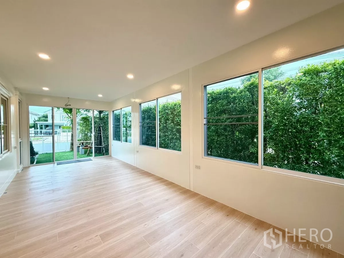 Detached House for rent in Bang Phli, Samut Prakan - Spacious multipurpose room with wood flooring and wraparound windows.