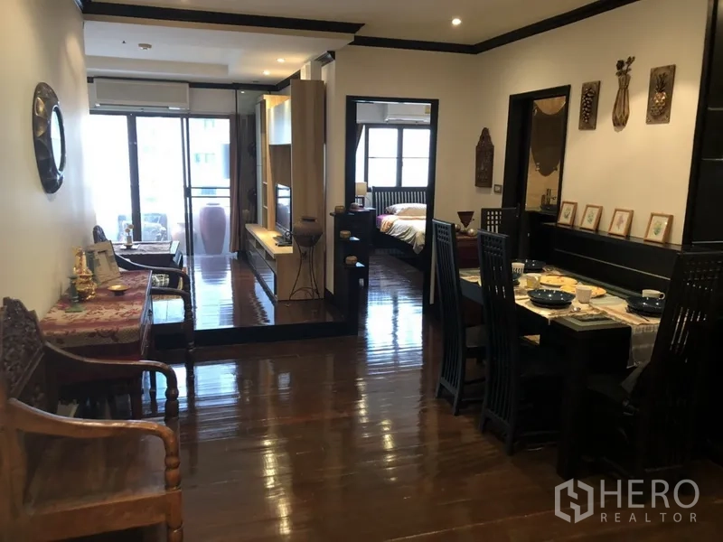 公寓 出租在Watthana, Bangkok - 木地板的餐客一体空间，通往阳台与卧室的走廊。