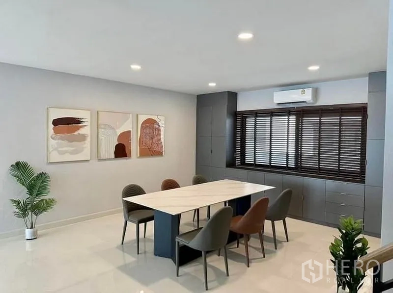 บ้าน ให้เช่าในBang Phli, Samut Prakan - โซนรับประทานอาหารกว้าง โต๊ะยาว 6 ที่นั่ง งานศิลป์ติดผนัง และตู้บิวท์อินใต้บานมู่ลี่