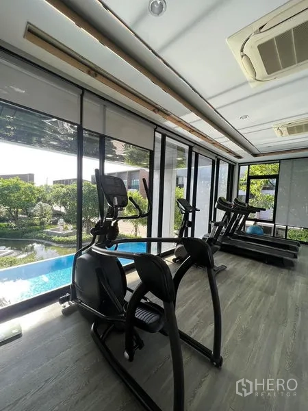 Townhouse for rent in Saphan Sung, Bangkok - Fitness room with cardio machines overlooking the pool and landscaped garden.