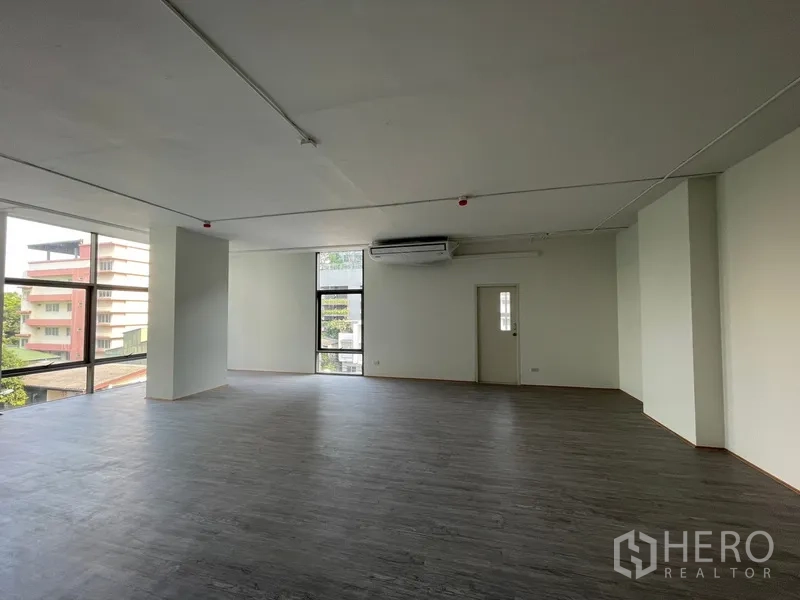 办公空间 出租在Bang Rak, Bangkok - 室内一角，墙挂空调与高窗。