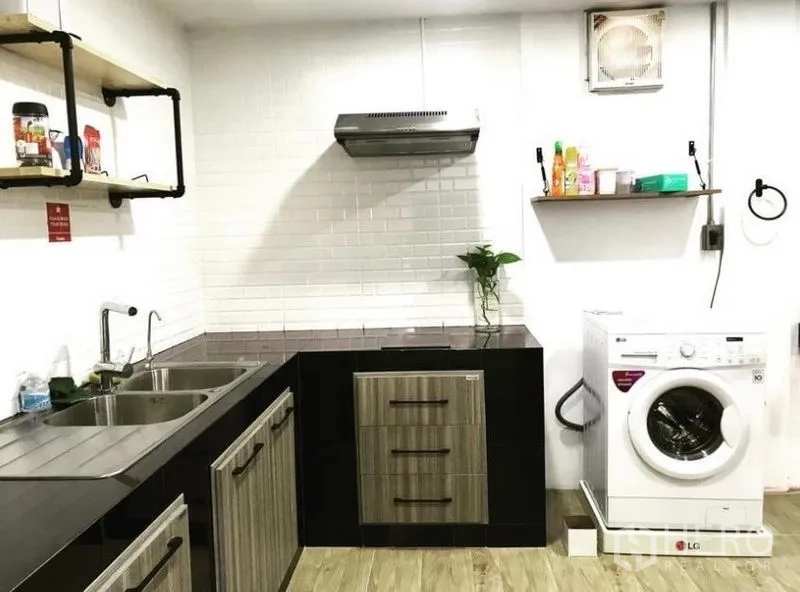 Townhouse for rent in Chatuchak, Bangkok - Modern kitchen with white subway tiles, double sink, cabinets and washing machine.