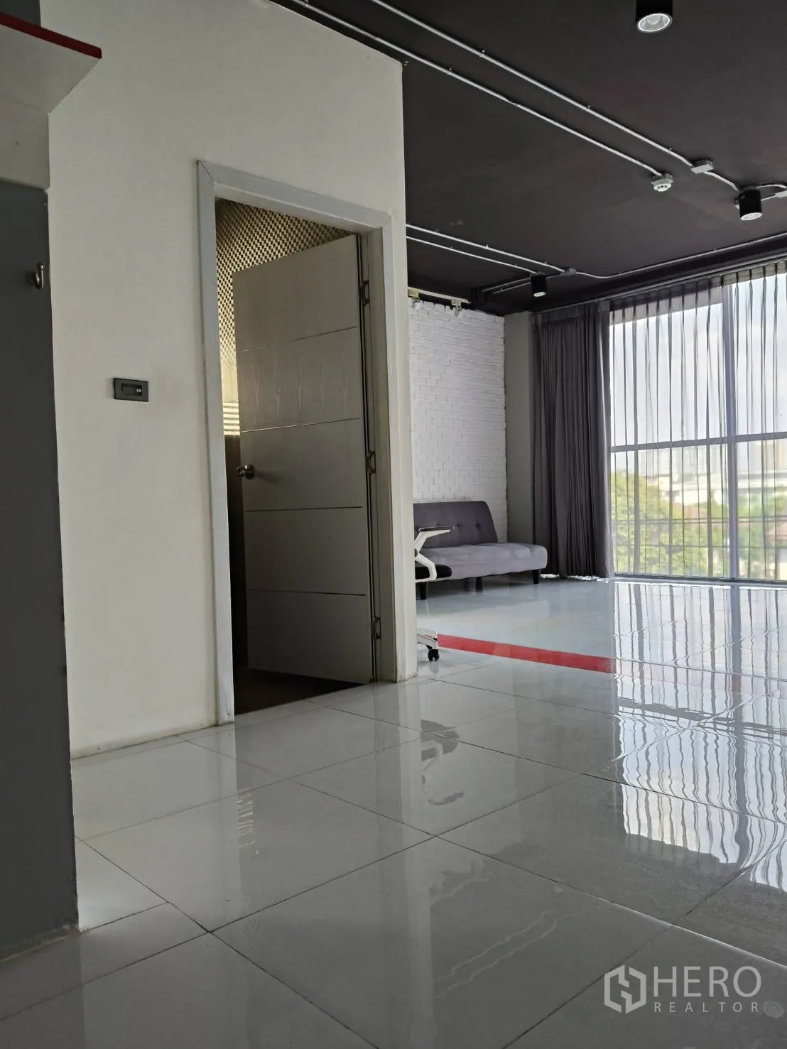 办公空间 出租在Khlong Toei, Bangkok - 浴室与阳台门旁的座位区，室内充足自然光。