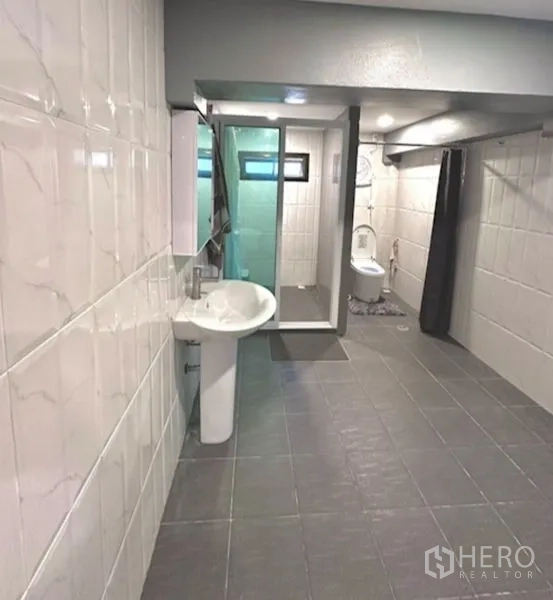 Detached House for sale in Bang Bua Thong, Nonthaburi - Modern bathroom with tiled walls, glass shower enclosure and toilet.