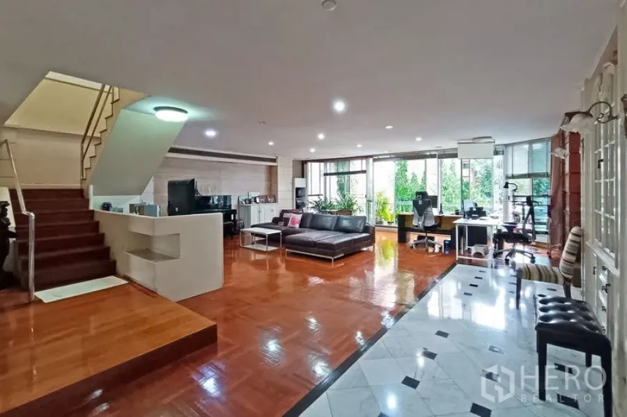 คอนโด ขายในBangkok - ห้องนั่งเล่นกว้างพร้อมบันได โซฟาตัวแอล และหน้าต่างมองสวน