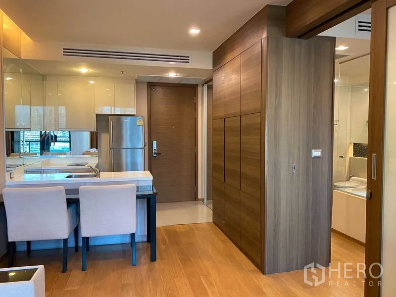 Condominium for rent in Bang Rak, Bangkok - Dining nook and entryway with wood floors and full-height wardrobes.