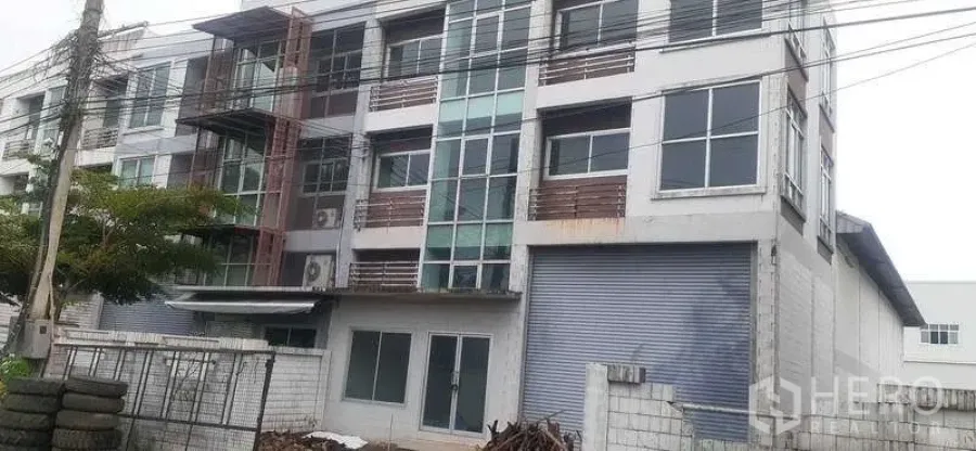 货栈 出租在Pathum Thani - 四层工业建筑，带仓库和大型卷帘门的外立面