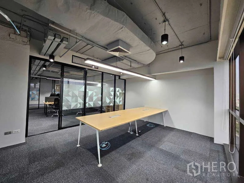 Office Space for rent in Ratchathewi, Bangkok - Corner office area with a long bench desk, pendant lights and large window city views.
