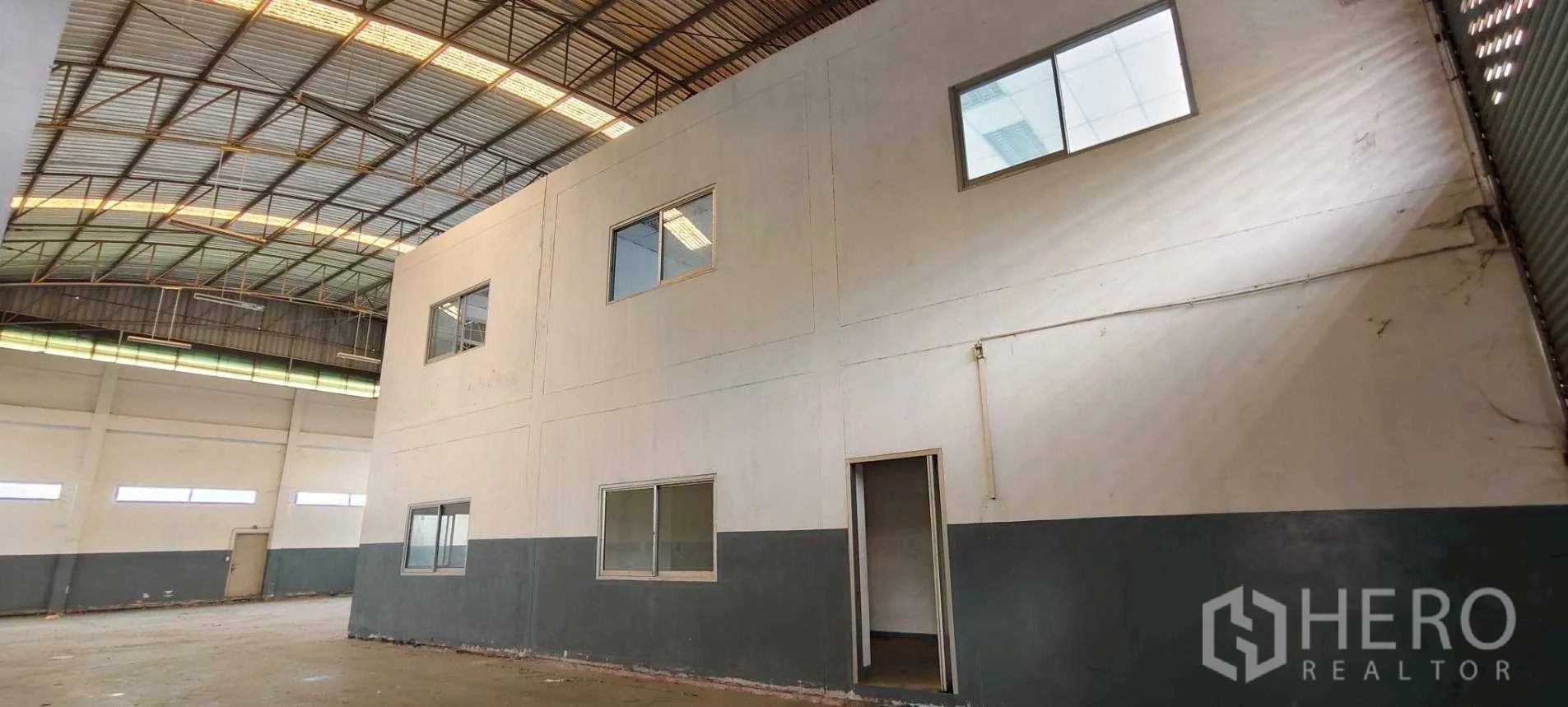 Factory for rent in Khlong Luang, Pathum Thani - Open production space showing windows, high ceiling and roll-up door.