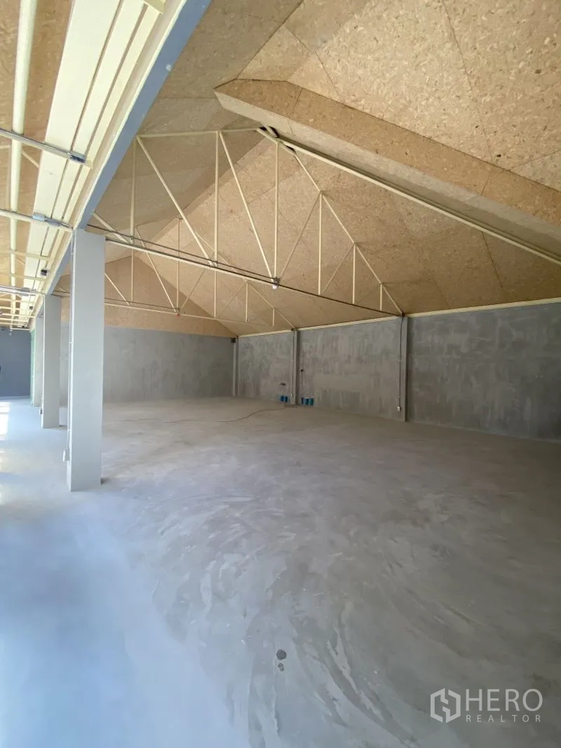 Retail Space for rent in Watthana, Bangkok - Spacious hall with pitched truss ceiling and polished concrete floor in minimalist style.