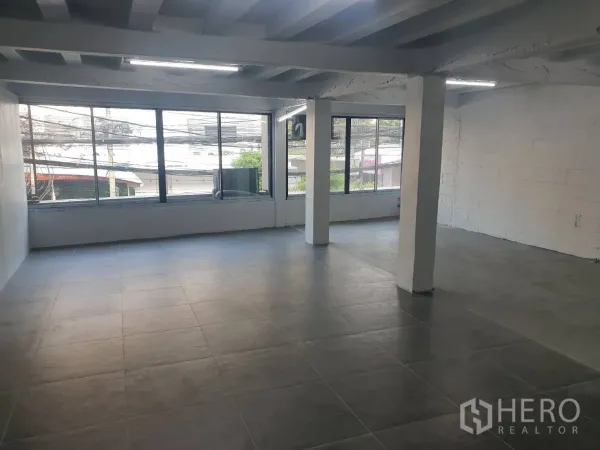 Retail Space for rent in Khlong Toei, Bangkok - Spacious retail floor with large windows, street views, exposed ceiling beams and tiled floor.