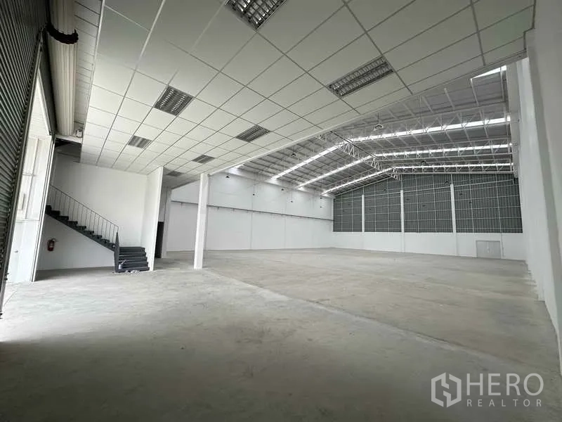 Factory for rent in Khlong Luang, Pathum Thani - Open production hall with skylight roof panels, clear span structure and durable concrete flooring.
