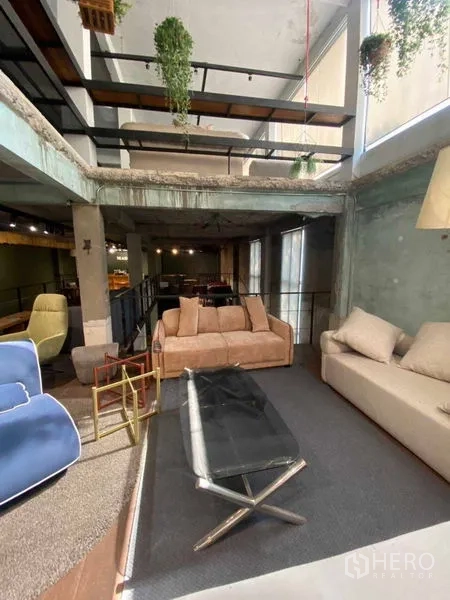 零售空间 出租在Bang Na, Bangkok - 阁楼风休息区，外露混凝土、悬挂绿植与夹层。