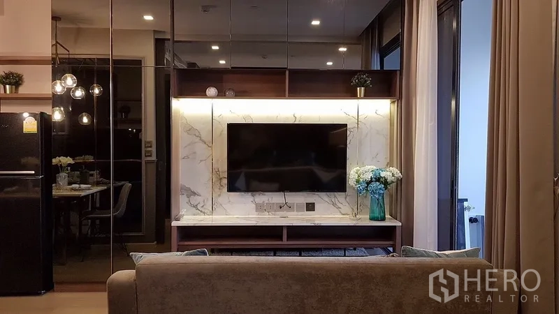 Condominium for rent in Watthana, Bangkok - Backlit marble media wall with mounted TV opposite the sofa in the lounge.