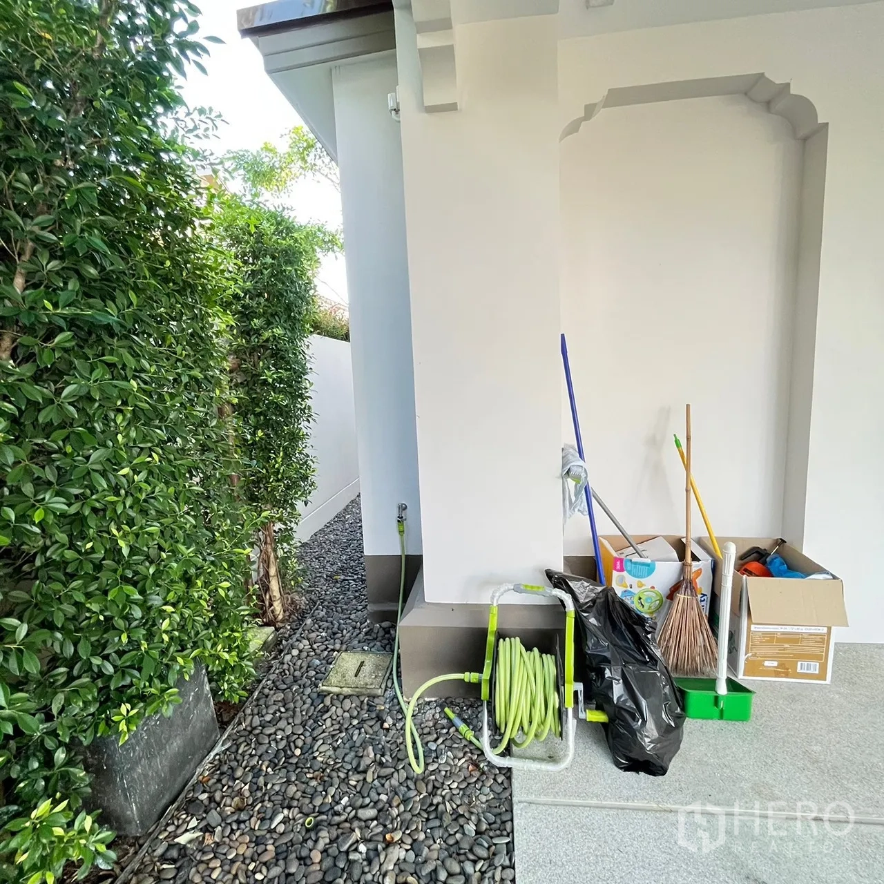 Detached House for rent or sale in Bang Khen, Bangkok - Side yard with pebble path, hose reel and privacy hedging.