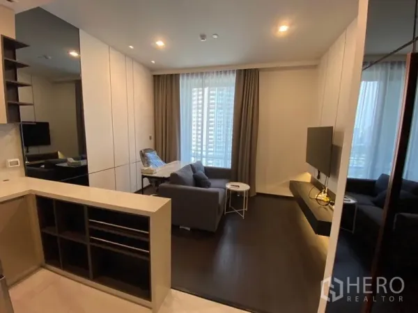 公寓 出租在Watthana, Bangkok - 通罗区域公寓客厅，沙发、挂墙电视与落地窗，现代明亮。